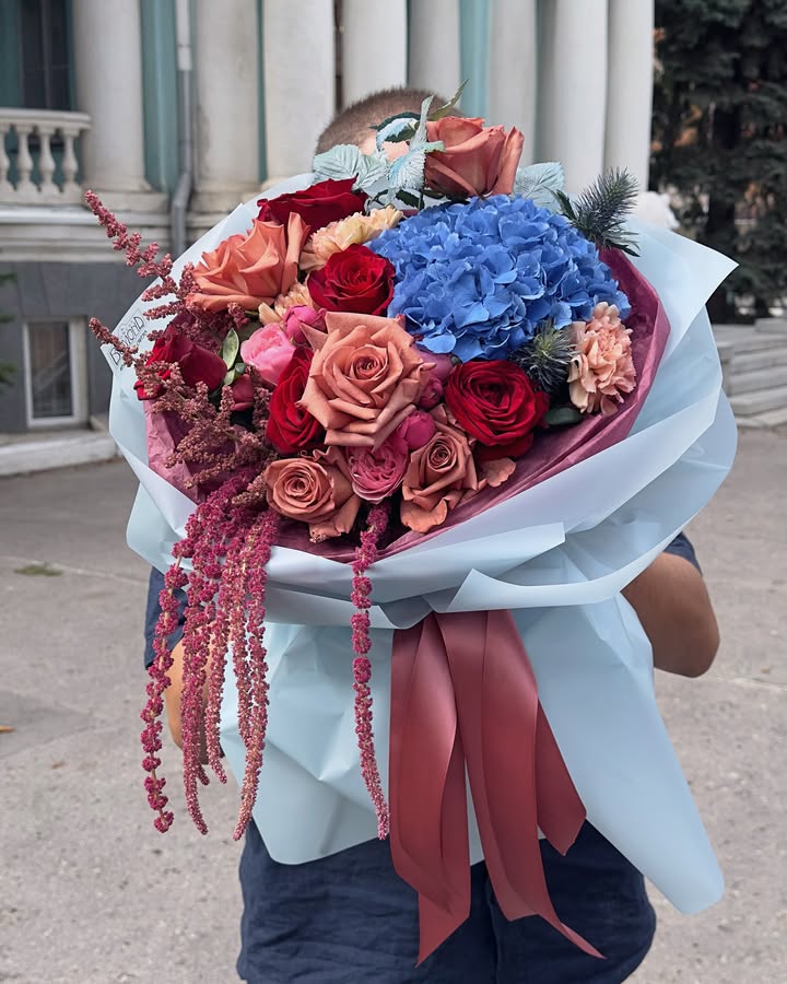 Bright bouquet with blue hydrangeas and multicolored roses