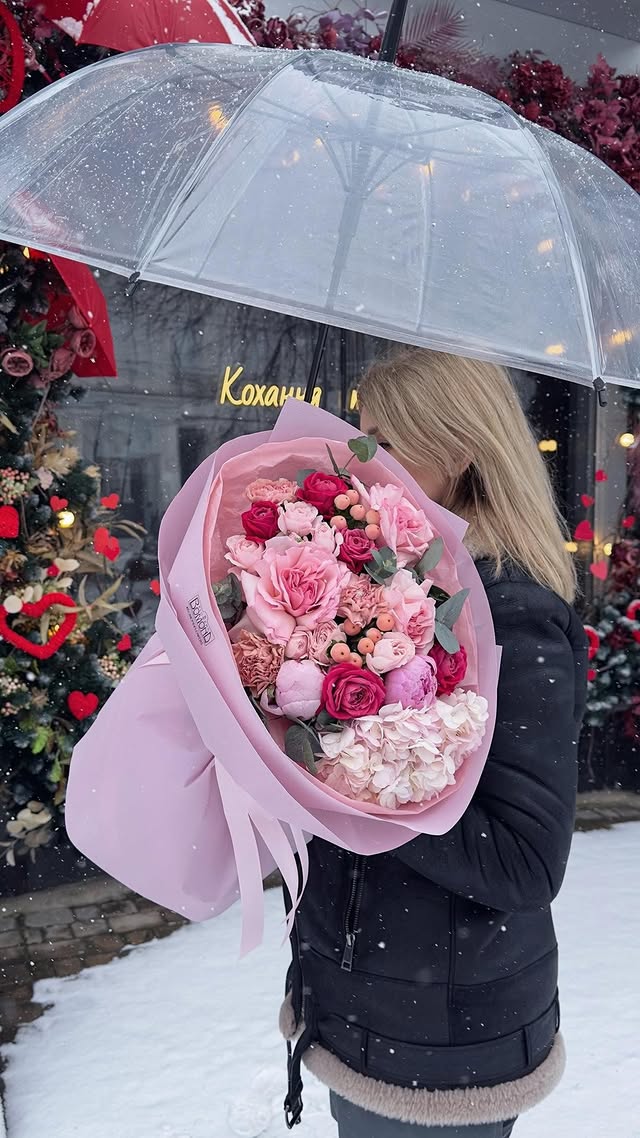 Mixed bouquet of roses and peonies in soft pink wrapping