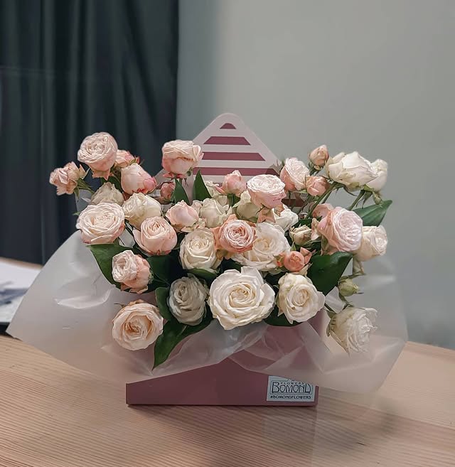 Bouquet of peach spray roses in a decorative envelope