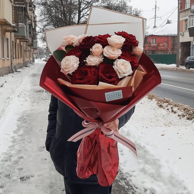 Bouquet of red and cream roses with stylish wrapping