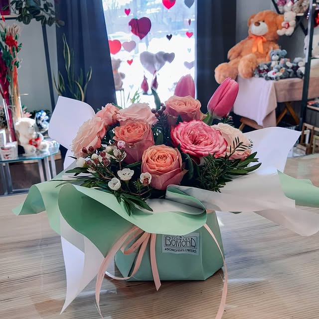 Compact bouquet of roses and tulips in mint wrapping