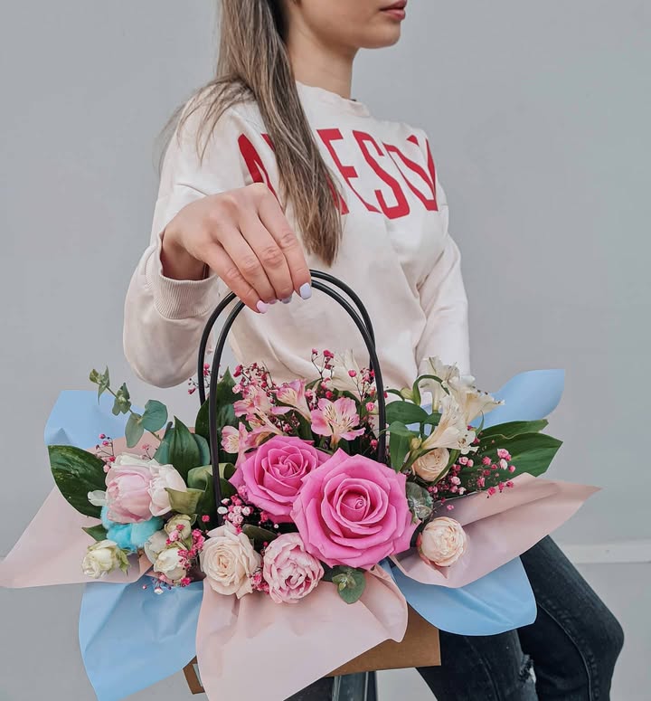 Flower arrangement in a handbag with pink and white roses