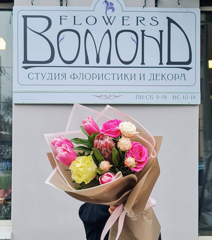 Bouquet of pink tulips, roses and white mini roses with protea