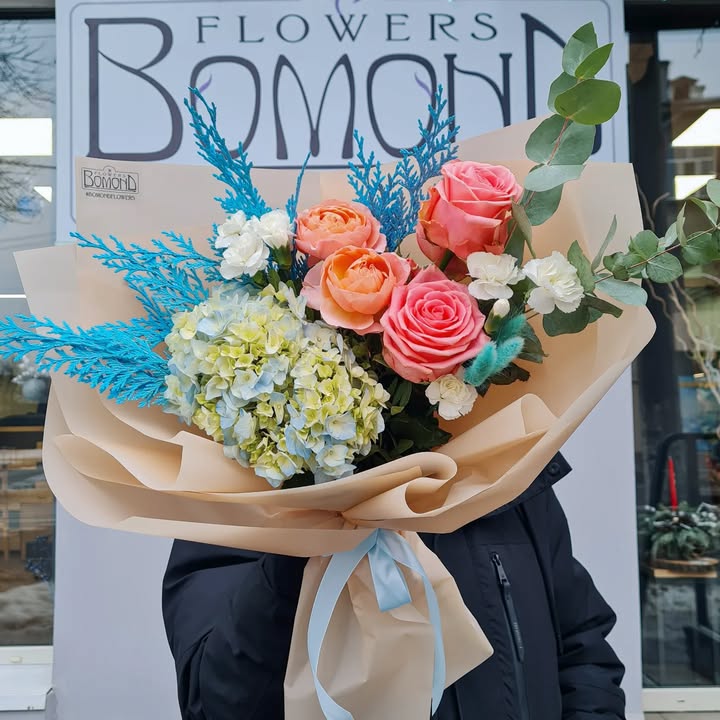 Delicate bouquet with peach roses and blue hydrangea