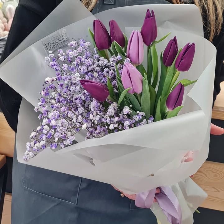 Bouquet of purple and light purple tulips with rainbow gypsophila