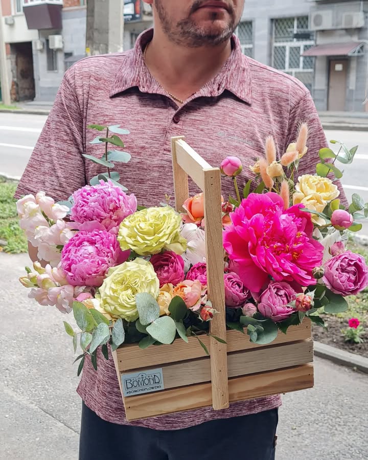 Gift bouquet with peony-like and pink flowers in wooden box