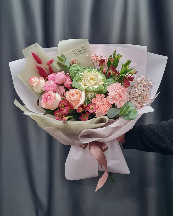 Delicate bouquet with roses and ornamental cabbage