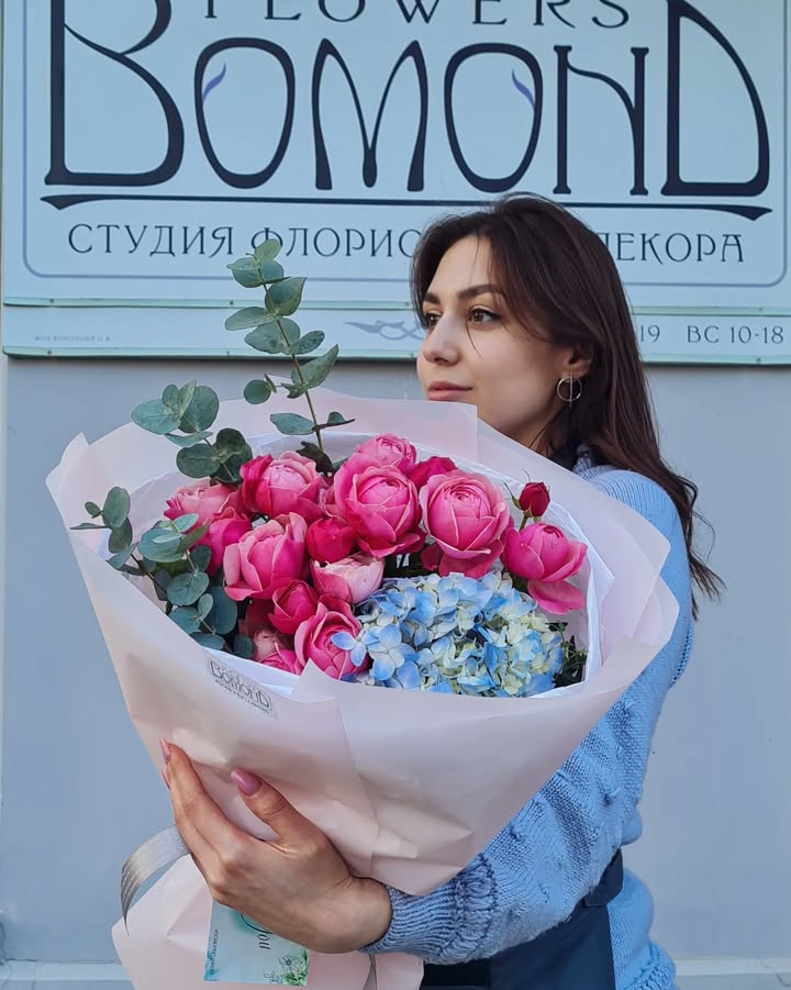 Bouquet of bright pink peony-like roses and blue hydrangea
