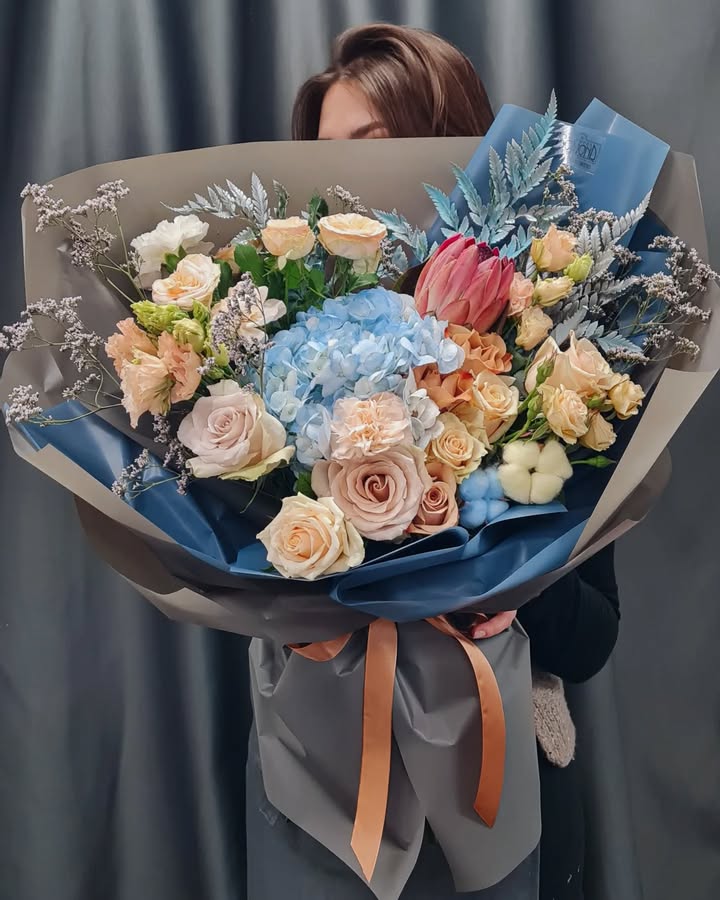 Large bouquet of roses, hydrangea, and protea in stylish wrapping