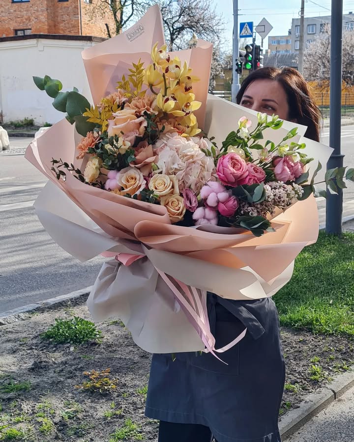 Large bouquet of roses, orchids, and cotton in soft pastel tones