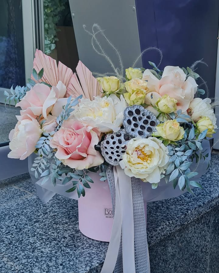 Floral arrangement with delicate roses and peonies in a hat box