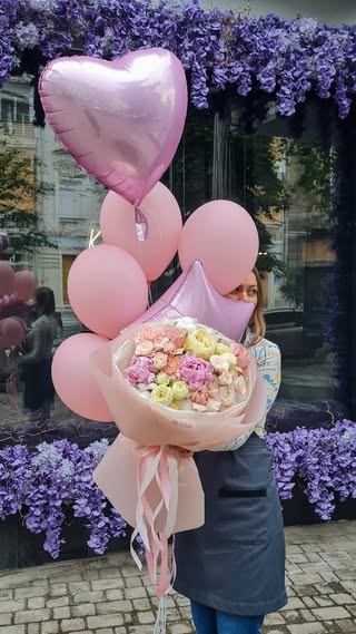 Bouquet of delicate pink and white flowers with heart-shaped balloons