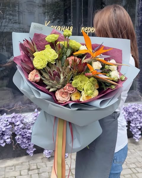 Exotic bouquet with bright tropical flowers and roses