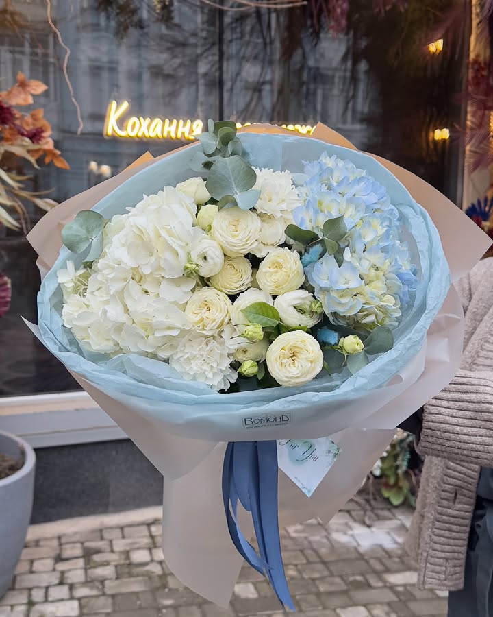 Delicate bouquet with white and blue hydrangeas and roses