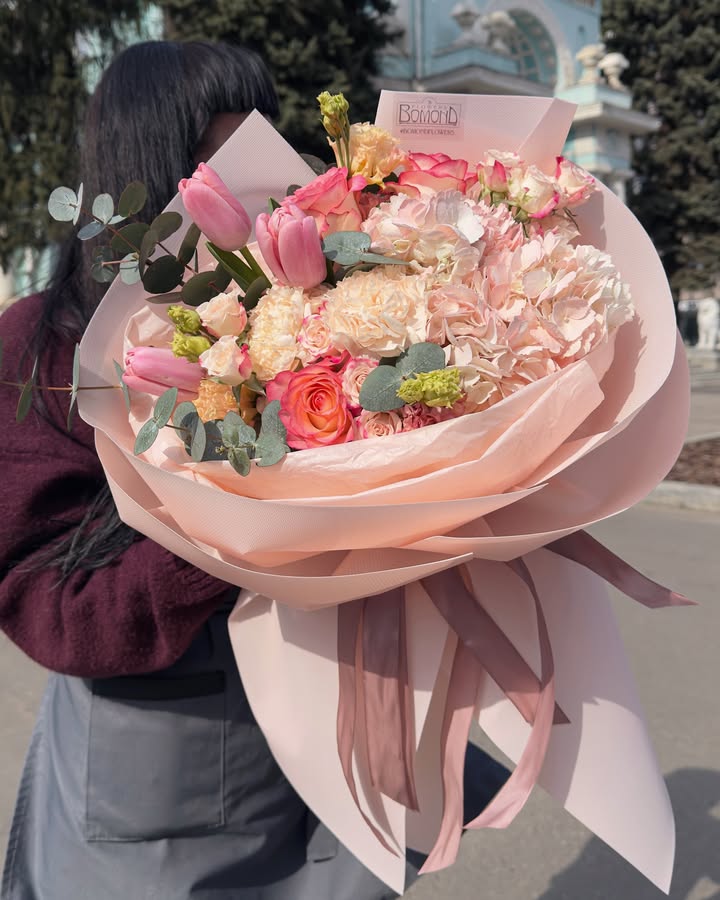 Bouquet with soft pink tulips and roses in wrapping