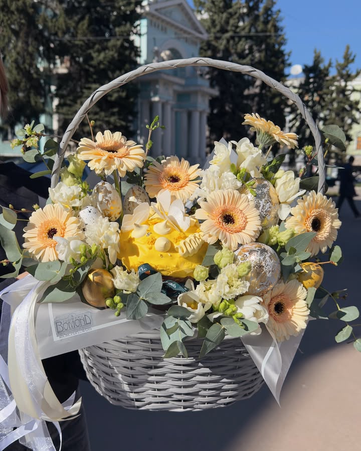 Easter floral arrangement with fresh flowers and Easter cake in a basket