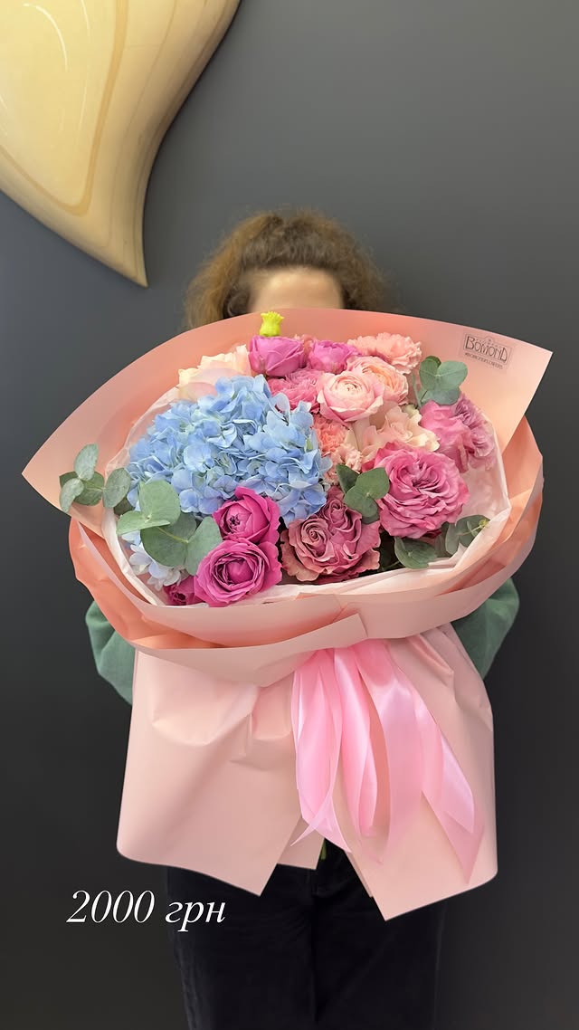 Bouquet of delicate mixed hydrangea and roses in soft pink wrapping