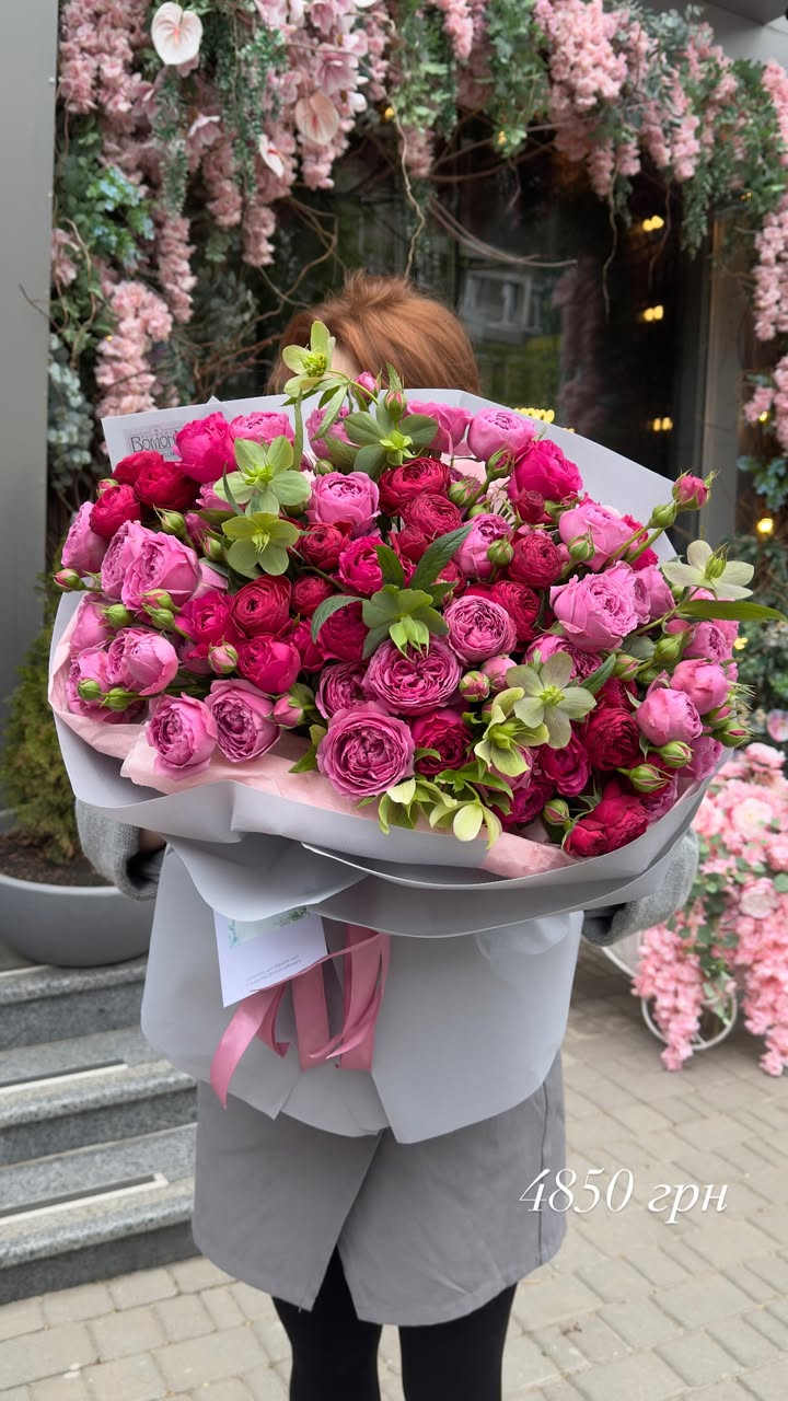 Large bouquet of pink and raspberry peony-like roses with green accents