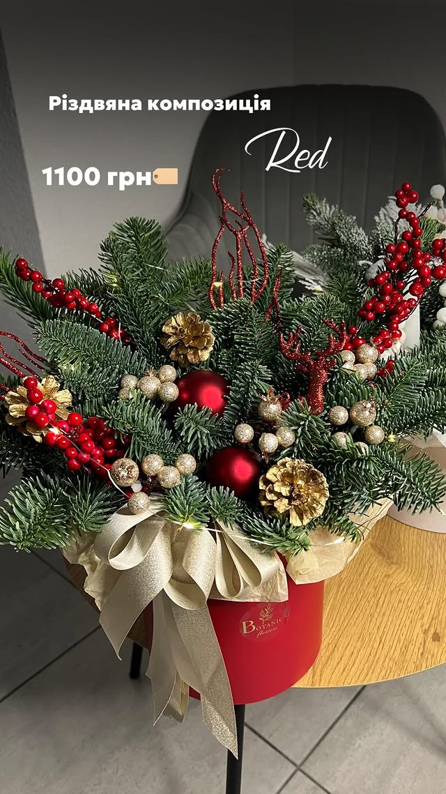 Різдвяна зимова композиція з хвойними гілками та червоними прикрасами