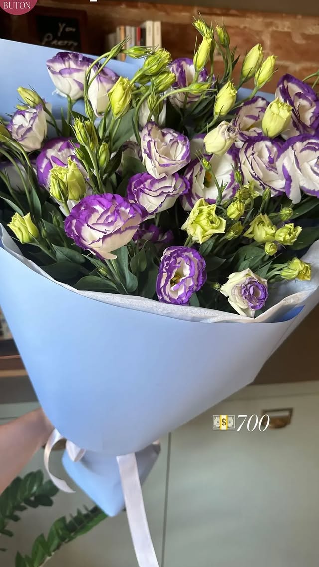 Букет бузкових лізіанту з жовтими ніжними квітами в блакитній упаковці