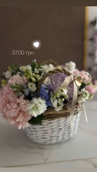 Плетений кошик з ніжним квітковим букетом пастельних відтінків